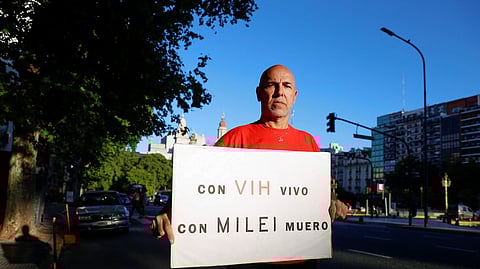 Claudio Mariani, 59, who was diagnosed as HIV positive in 1993, holds a placard that reads "with HIV I live, with Milei I die", in Buenos Aires, Argentina, November 29, 2024.