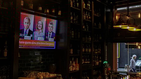 FILE PHOTO: A TV screen in a bar displays portraits of presidential candidates Calin Georgescu, Elena Lasconi and Marcel Ciolacu, with results of the first round of the presidential election, in Bucharest, Romania, November 25, 2024. 