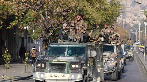 Rebel fighters ride on vehicles, after rebels seized the capital and ousted President Bashar al-Assad, in Damascus, Syria, December 9, 2024. 