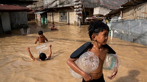 FILE PHOTO: Children play along a flooded street following super typhoon Man-Yi, in Cabanatuan, Nueva Ecija, Philippines, November 18, 2024. 