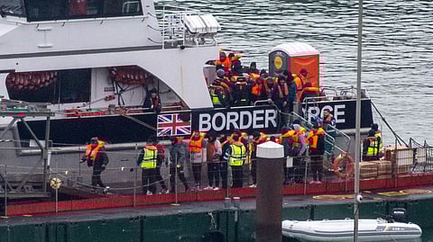 FILE PHOTO: People, believed to be migrants, disembark from a British Border Force vessel as they arrive at the Port of Dover, in Dover, Britain, December 29, 2024. 