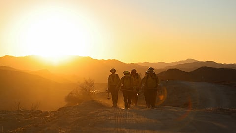 Members of a CalFire crew work to mop up hotspots from the burn scar of the Palisades Fire near Mulholland Drive in Los Angeles, California, U.S., January 15, 2025. 
