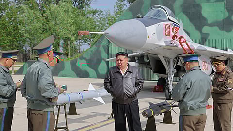 North Korean leader Kim Jong Un talks to military members as he inspects projectiles during a visit to an airfield in this photo released by the Korean Central News Agency, May 16, 2025. 