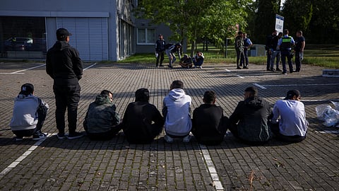 FILE PHOTO: Suspected illegal migrants sit on the ground after they were detained by German police during their patrol along the German-Polish border to prevent illegal migration, in Forst, Germany, September 20, 2023. 