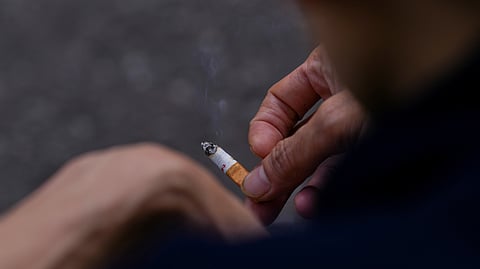 FILE PHOTO: A man holds a cigarette in his hands in London, Britain April 11, 2023. 