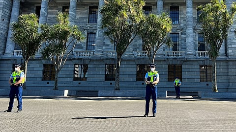 FILE PHOTO: Police stand guard as protesters gather on the grounds of New Zealand Parliament, as they demonstrate against what they consider as government encroachment on freedoms, in Wellington, New Zealand, August 23, 2022. 