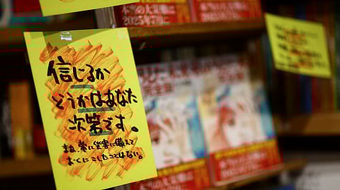 A sales banner written by the store reading 'Whether you believe it or not is up to you' is displayed next to the comic book titled 'The Future I saw', authored by manga artist Ryo Tatsuki, on the shelf at the book store Village Vanguard in Tokyo, Japan June 30, 2025. 