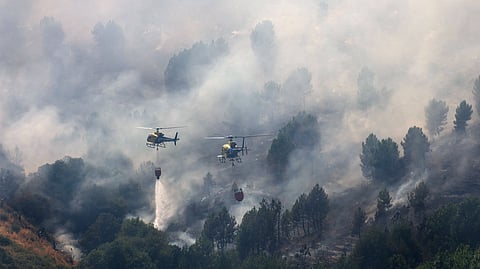 Helicopters battle wildfire on the outskirts of Mombeltran, Spain, July 29, 2025. 