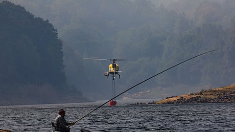 A helicopter loads water during operations to battle wildfire in the area of A Espasa, as seen from Chandrexa de Queixa, Spain, August 12, 2025. 

