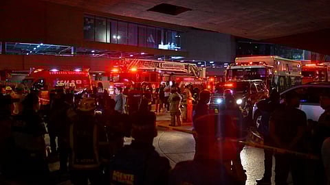 Security personnel, firefighters and authorities stand at the site where a vehicle exploded outside a shopping mall, as a second vehicle containing explosives was found nearby, but did not detonate and was immediately neutralized, according to Ecuador's Interior Minister John Reimberg, in Guayaquil, Ecuador October 14, 2025. 