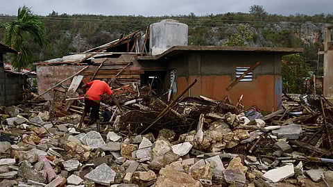 A resident removes debris outside his house in the aftermath of Hurricane Melissa, in Santiago, Cuba, October 29, 2025. 