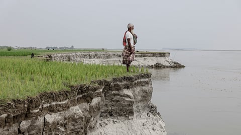 Kosim Uddin, 50, looks toward the site of his vanished home as he poses for a picture on an island in the Brahmaputra River, where he recently relocated due to erosion, in Kurigram, Bangladesh, October 29, 2025. 