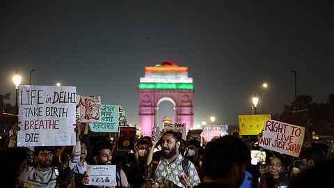 Protesters hold placards in front of the India Gate during a protest against air pollution in New Delhi, India, November 9, 2025. 