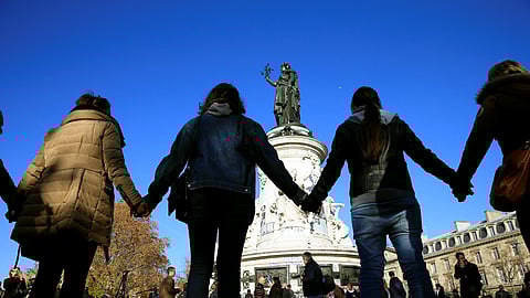 FILE PHOTO: People hold hands to form a human solidarity chain near the site of the attack at the Bataclan concert hall in Paris, November 15, 2015.