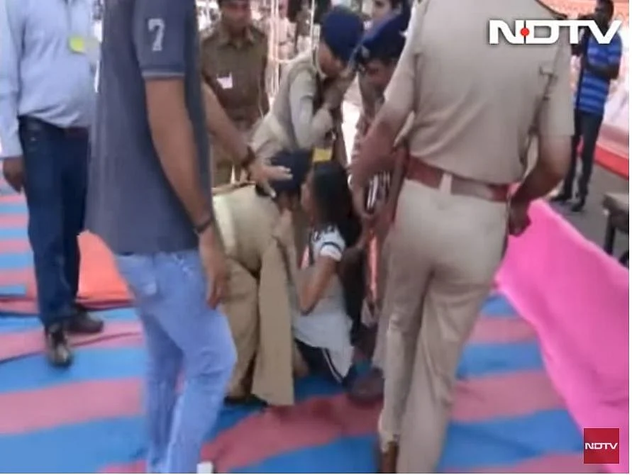 A screengrab showing police personnel forcibly evict Rupal Tadvi from Chief Minister’s rally.