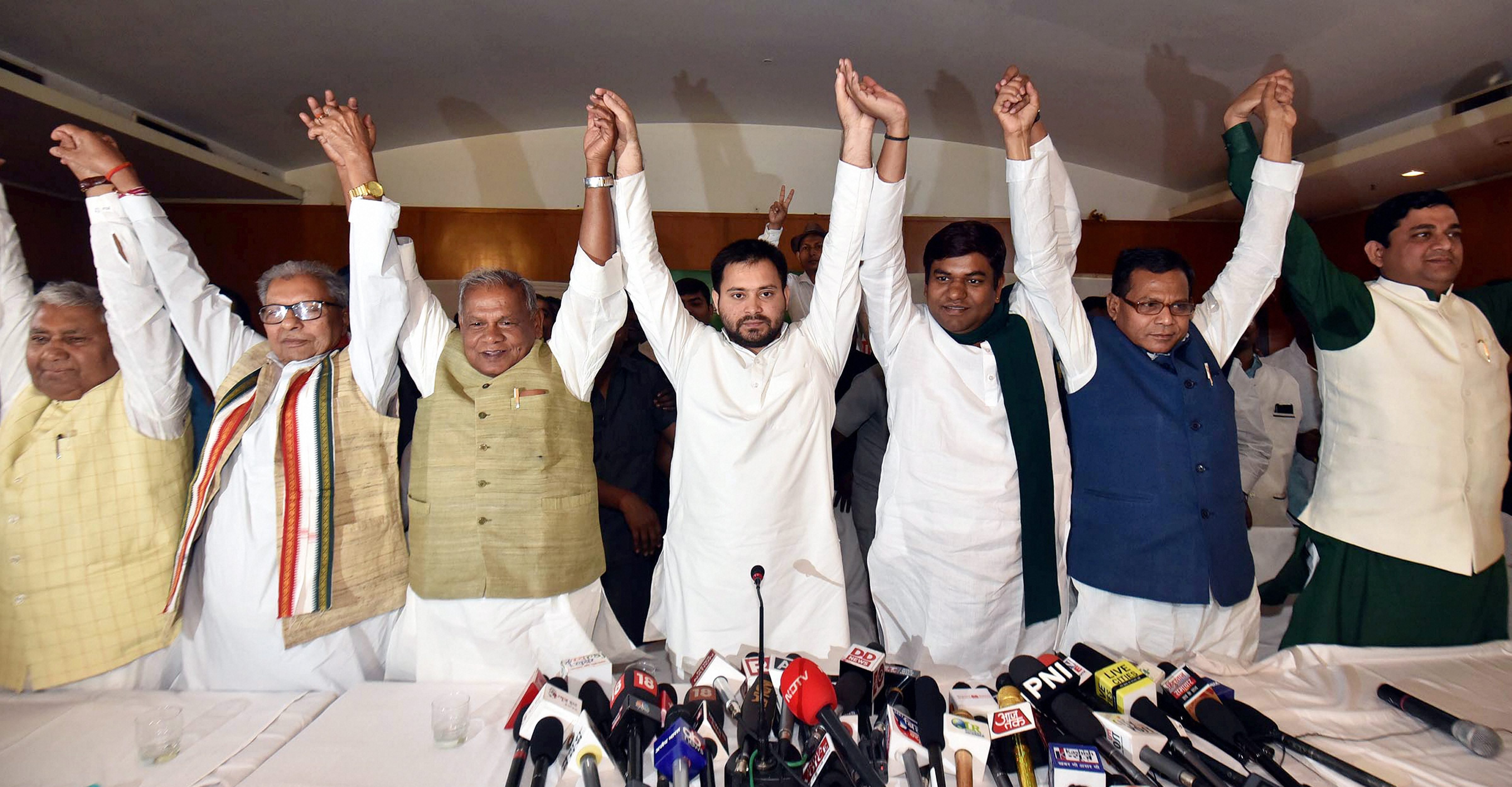 Rashtriya Janata Dal leader Tejashwi Yadav, Hindustani Awam Morcha (Secular) Chief Jitan Ram Manjhi and other leaders join hands after announcing the grand alliances candidates list for the upcoming Lok Sabha elections 2019, in Patna (PTI)