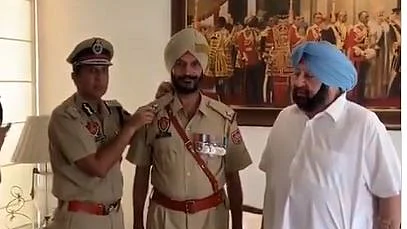 Amarinder Singh piping ASI stars on Satnam Singh who was part of the Army team that captured Tiger Hill during Operation Vijay in 1999, on July 29, 2019.