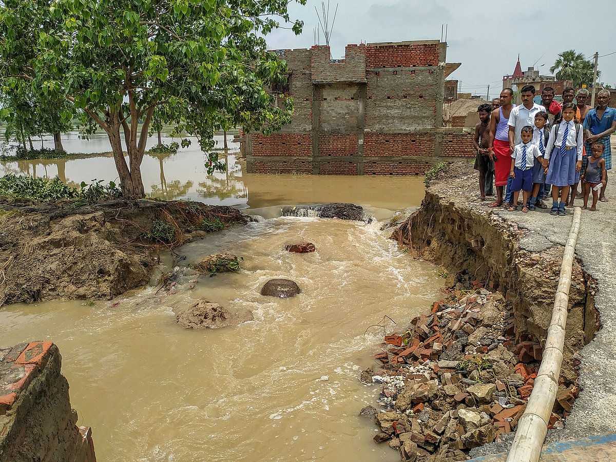 Villagers look on at a flooded area, in Ratanpur village under East Champaran district of Bihar