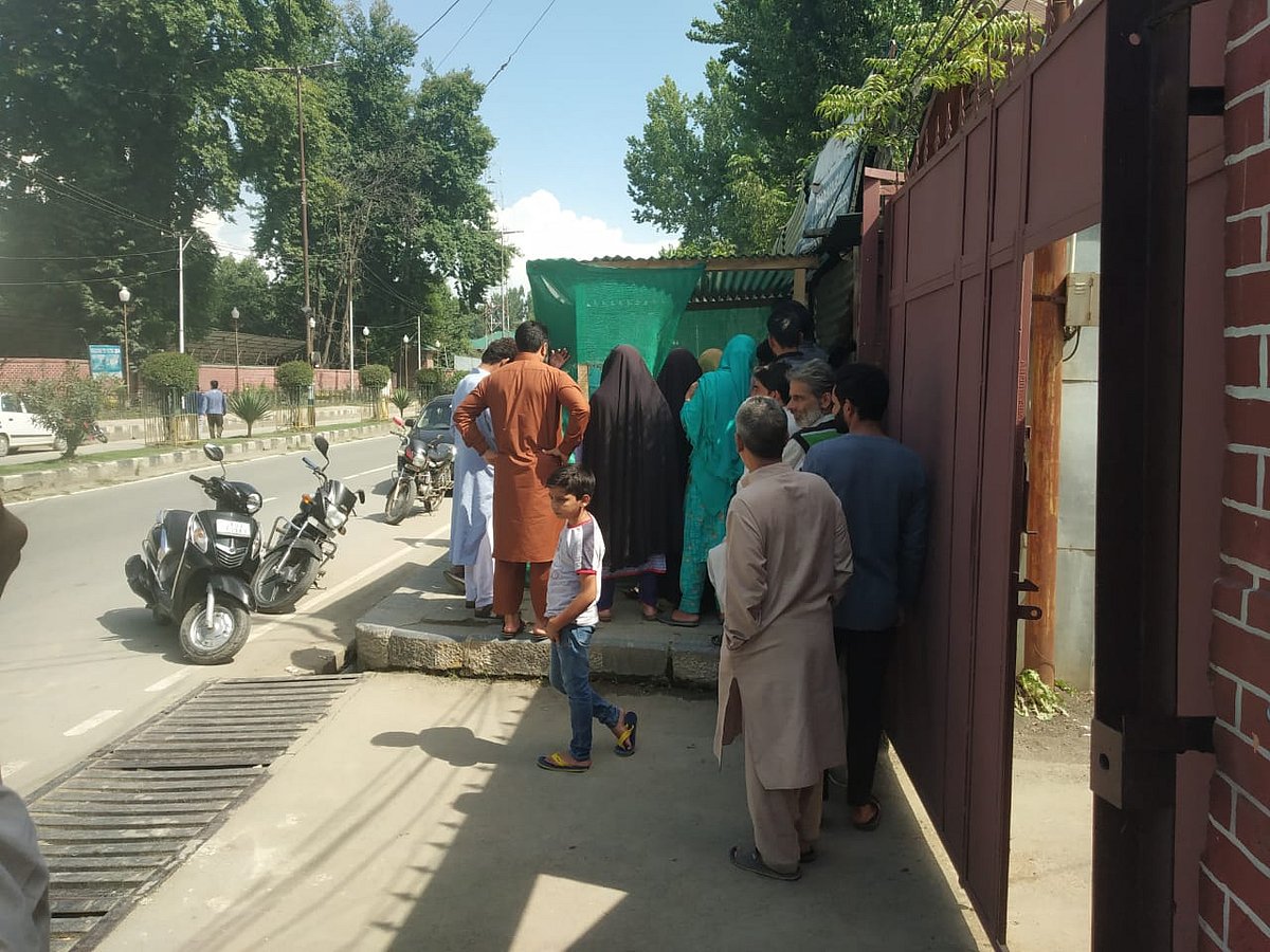 People waiting to call near a police post in Anantnag