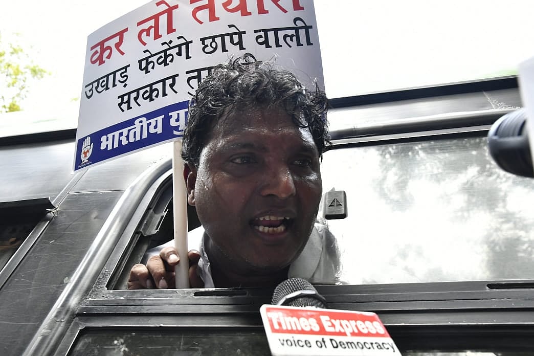 A Youth Congress activist being taken away in a police vehicle from the site of protest.