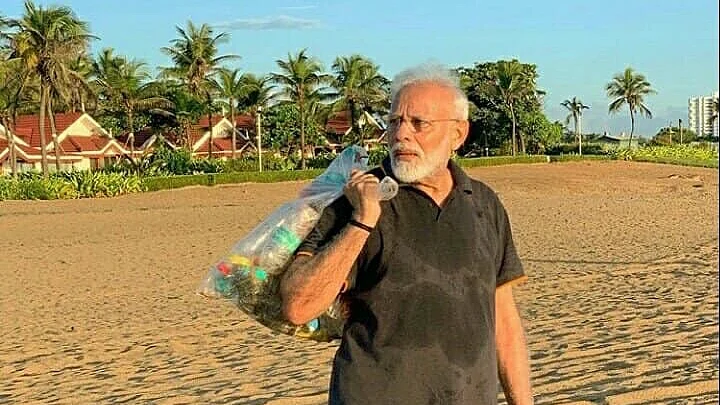 PM Narendra Modi with a bagful of garbage he picked up on the beach .