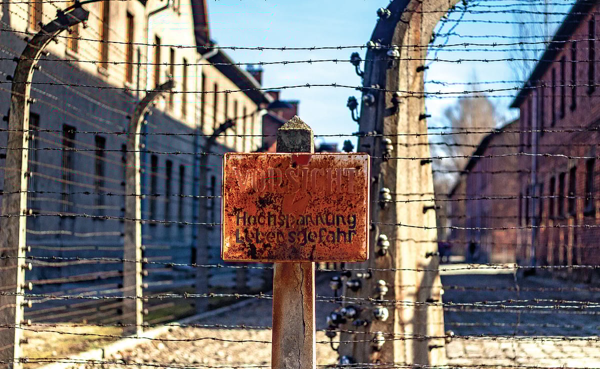 A fading sign in German warns of high voltage next to a barbed wire fence at the Auschwitz I memorialconcentration camp site in Oswiecim, Poland