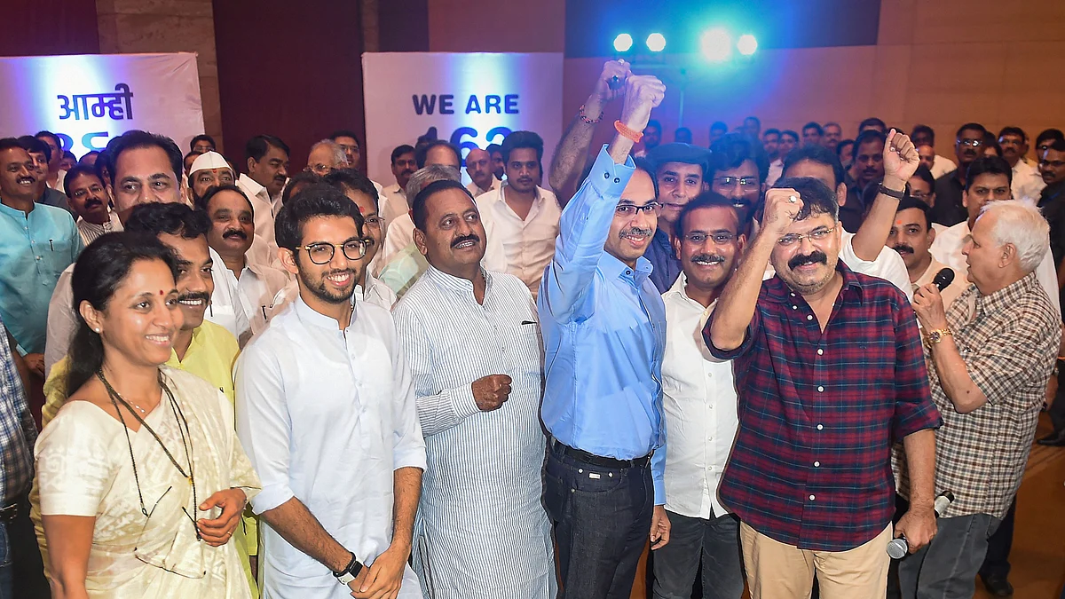 Sena chief Uddhav Thackeray and NCP MLA Jitendra Awhad raise their fists as a sign of unity at the parade of NCP-Cong-Sena MLAs in Mumbai on Monday. NCP’s Supriya Sule and Congress’ Ashok Chavan are also in the frame.