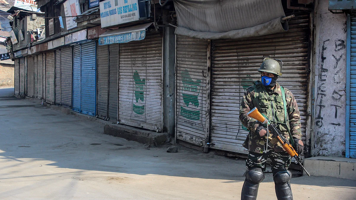 A security personnel stands guard at a closed market, in Srinagar (PTI Photo)