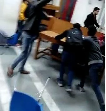 Panic stricken students inside Jamia library scramble to take cover as glass shards fly around due to teargas shells firing by Delhi police from outside. (File Photo)