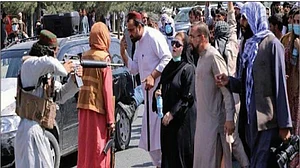 Taliban pointing a rifle at a woman
