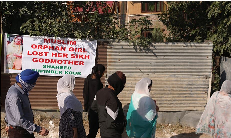 People walk past a poster seeking justice for Supinder Kaur’s death on
their way to the deceased school principal’s house (Photo: Mir Zeeshan)