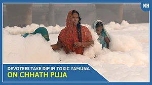 Devotees standing waist deep in toxic foam in Yamuna