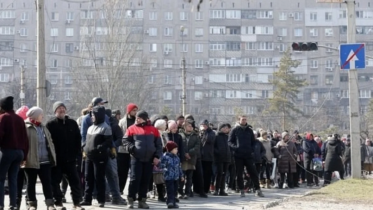 People queue up to receive humanitarian relief supplies in Mariupol, Ukraine