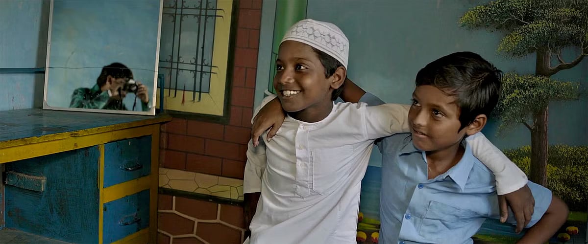 A still from the film where the two boys pose like Amitabh Bachchan from Deewar