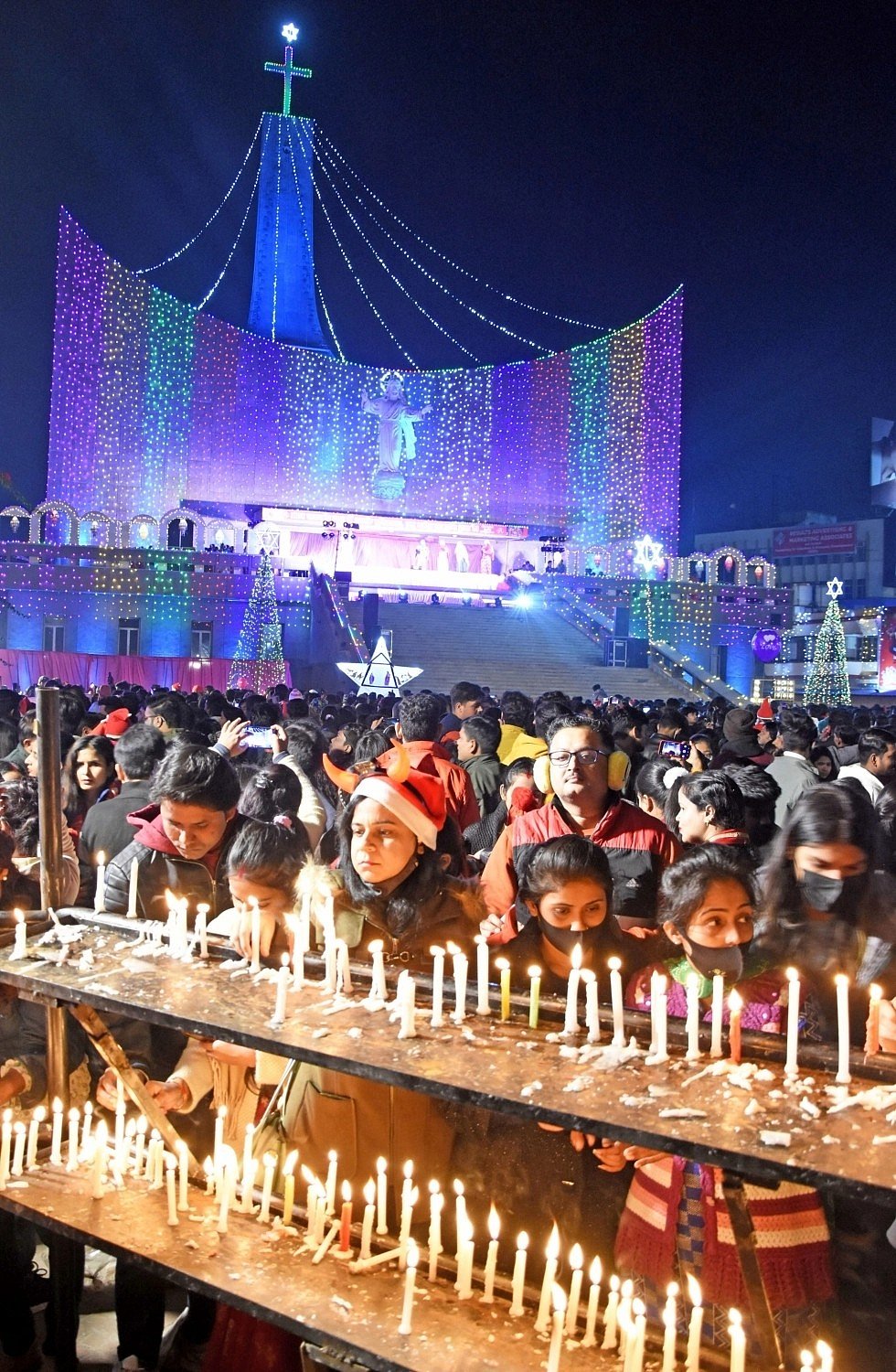 People light candles and offer prayers at St Joseph Cathedral church to celebrate the Christmas festival in Lucknow on Sunday, 25 Dec. 2022. 