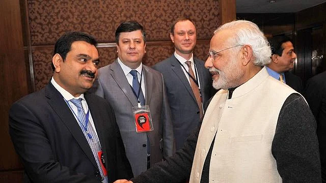 Gautam Adani (left) has a warm handshake with PM Modi