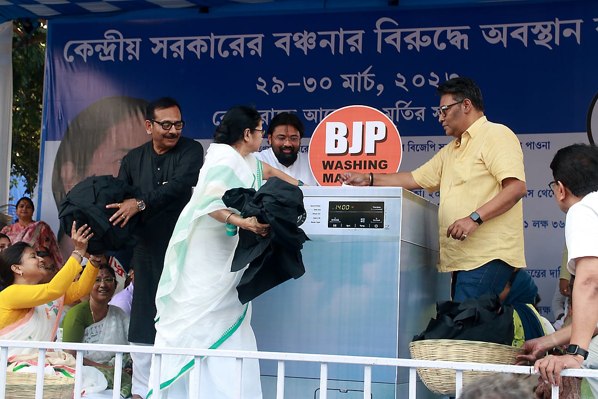 Mamata Banerjee took a 'washing machine' jibe at the 'dharna' where she was seen dropping black clothes inside the machine and picking up white ones. Slogans of “BJP washing machine” were raised at the protest.