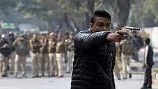 A Hindu man opens fire at anti-CAA protesters in Jamia Nagar, Delhi January 2020. A posse of policemen just watch from the distance. 