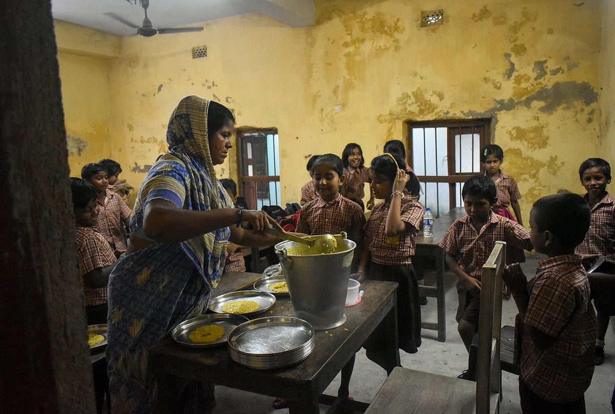 A school worker distributes a mid-day meal in a government primary school (photo: Getty Images)