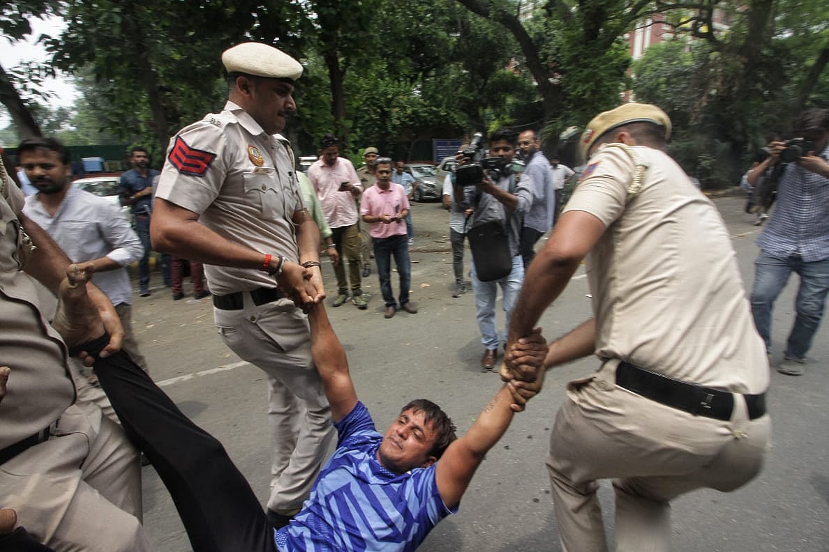 A wrestler being dragged to the police van (Photo: Vipin)