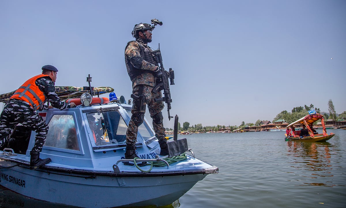 An Indian paramilitary commando stands guard on his boat 
at Dal ahead of the G20 summit on May 20, 2023 in Srinagar. (Photo: Yawar Nazir/Getty Images)