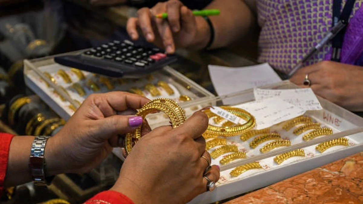 A customer holds a pair of gold bangles in her hands at a jewellery shop (Getty Images)
