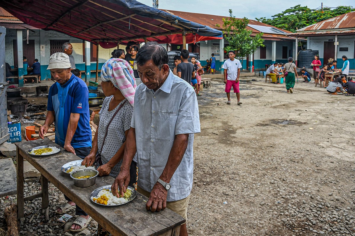 Churachandpur, Manipur: Displaced people take food at a relief camp at Saidan village. (photo: Getty Images)