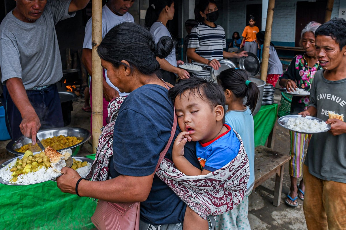 Churachandpur, Manipur: A mother carries her child at a relief camp in Rengkia village (photo: Getty Images)