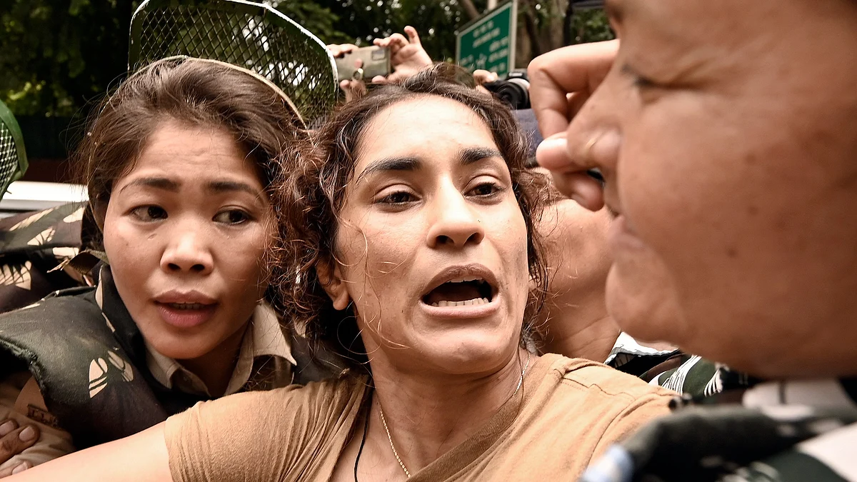 Security personnel detaining Vinesh Phogat during the wrestlers' protest march toward Parliament on 28 May in New Delhi (photo: National Herald archives)