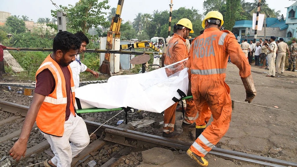 Rescue workers carry the body of a victim along the tracks at the accident site of a three-train collision near Balasore at Odisha, India, 03 June 2023. (photo: Getty Images)