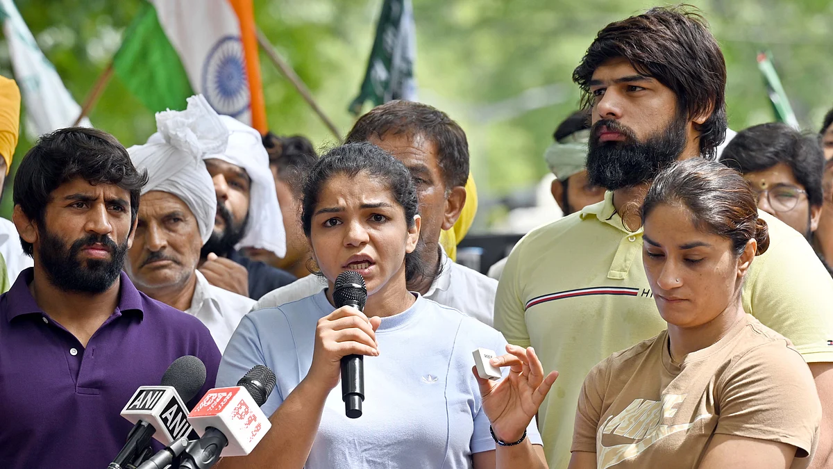 Wrestlers Vinesh Phogat, Sakshi Malik and Bajrang Punia speak with the media during their protest (photo: Getty Images)