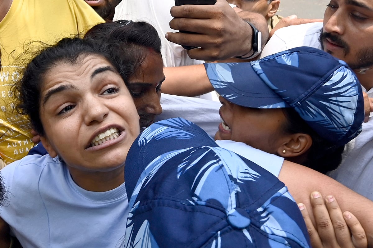 Security personnel detain wrestler Sakshi Malik during wrestlers' protest march towards the new Parliament building on 28 May 2023 in New Delhi. (photo: Getty Images)