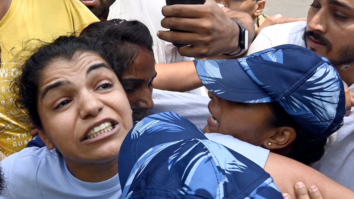 Security personnel detain wrestler Sakshi Malik during wrestlers' protest march towards the new Parliament building on 28 May 2023 in New Delhi. (photo: Getty Images)