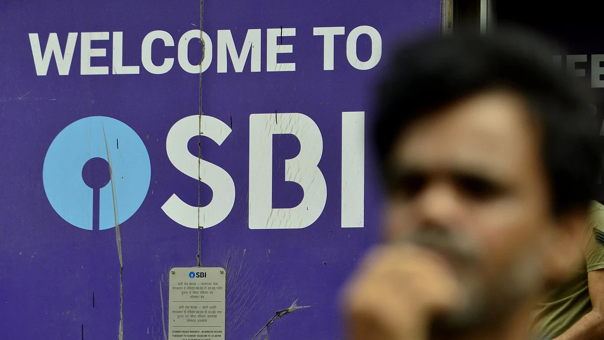 File photo of a man standing in front of SBI (State Bank Of India) logo (photo: Getty Images)